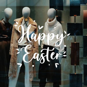 May include: A shop window display featuring mannequins dressed in different outfits. The mannequins are positioned in a row and the window is adorned with a sign reading "Happy Easter".