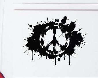May include: A black vinyl decal featuring a peace sign symbol surrounded by an abstract ink splatter design. The graphic is applied to the white rear panel of a van, showcasing a high-contrast look with dripping paint effects and circular edges.