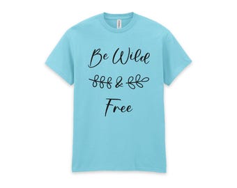 May include: A light blue short-sleeve t-shirt featuring the black text Be Wild & Free with a small decorative leaf graphic between the words. The shirt has a crew neckline and a simple, solid-colored design on the front of the garment.