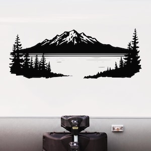 May include: Black and white mountain and lake decal. The design features a mountain range with snow-capped peaks, a calm lake, and silhouetted pine trees on either side. The decal is applied to a white surface.