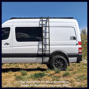 Puede incluir: Una furgoneta blanca con una escalera negra en el lateral y una calcoman&iacute;a en blanco y negro que dice "THE VAN LIFE" en la parte trasera.