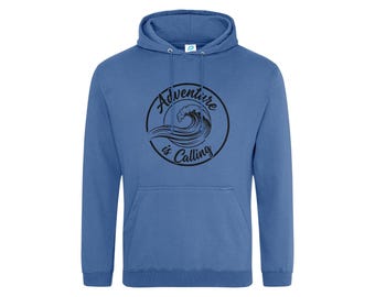 May include: A blue hooded sweatshirt featuring a black circular graphic on the chest. The graphic depicts a stylized ocean wave with the text "Adventure is Calling" written in a cursive font along the inner border of the circle.
