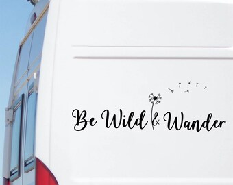 May include: White vehicle with a black decal reading "Be Wild & Wander" in a cursive font. The decal features a dandelion with seeds. The vehicle has a red taillight.