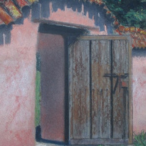 May include: A weathered wooden door with a metal latch is partially open, revealing a pink building with a red tile roof. The door is set in a wall with a dark brown wooden frame.