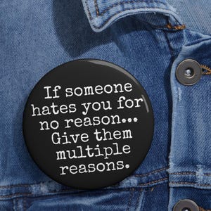 May include: A black button with white text that reads "If someone hates you for no reason... Give them multiple reasons."