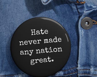 May include: A black button with white text that reads "Hate never made any nation great."