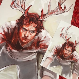 Puede incluir: Una ilustración de acuarela de una persona con cuernos de ciervo y salpicaduras de sangre en su ropa. La persona está mirando directamente al espectador con una expresión seria.