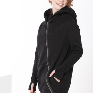 May include: A black hooded zip-up jacket with a long asymmetrical hemline and thumbholes.