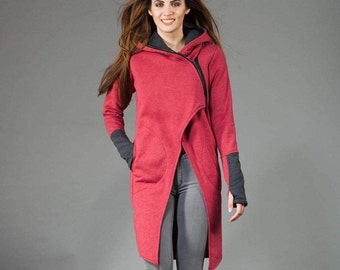 May include: A long, red hooded sweatshirt with a zipper closure and a diagonal design. The sweatshirt has a large pocket on the front and thumbholes on the sleeves.
