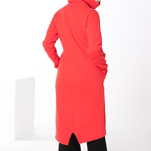 May include: A long red dress with a high, folded collar and a slit in the back. The dress is made of a soft, comfortable fabric.