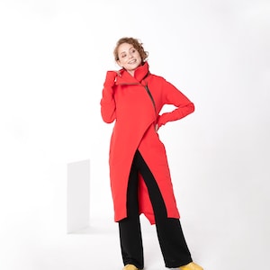 May include: A red long-sleeved jacket with a high collar and a zipper down the front. The jacket is worn over black pants.