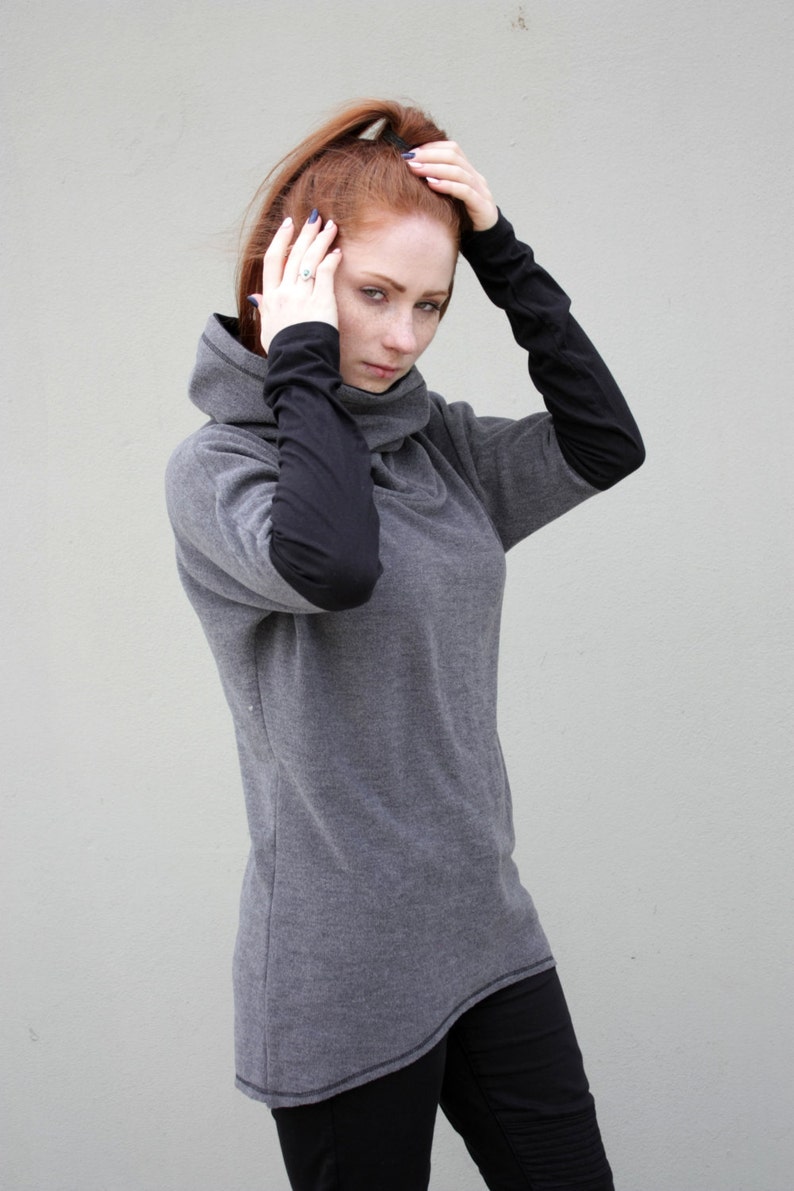 K&ouml;nnte beinhalten: Ein graues Langarmshirt mit schwarzen &Auml;rmeln und einem hohen Rollkragen.