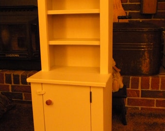 This is a small step back hutch for children or it could be used for a small  additional piece used in any room. Painted a candelight paint