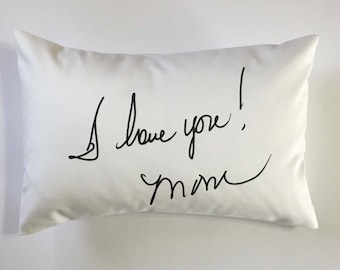 May include: White pillow with black handwritten text that says "I love you! Mom"