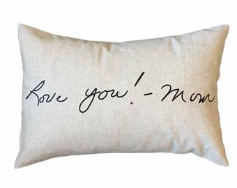 May include: A beige pillow with the text "Love you! - Mom" written in black cursive.