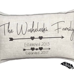May include: A gray linen pillow with black text that reads "The Washeleski Family Established 2013 Expanded 2017". The text is accompanied by two arrows and hearts.