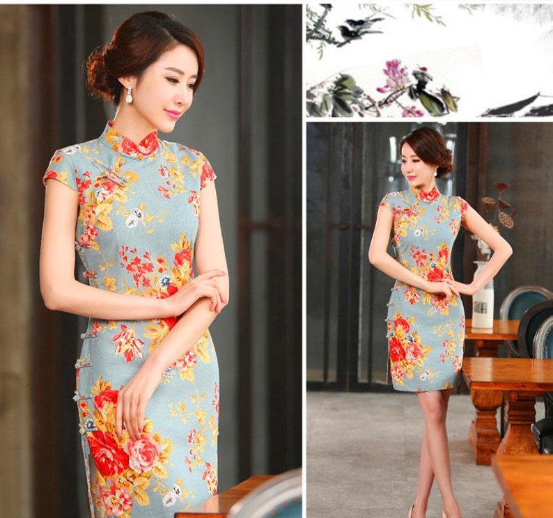 Puede incluir: Vestido azul claro de manga corta con cuello mandar&iacute;n y estampado floral. El vestido presenta flores rojas, amarillas y naranjas. El vestido tiene una silueta ajustada y llega a la rodilla.