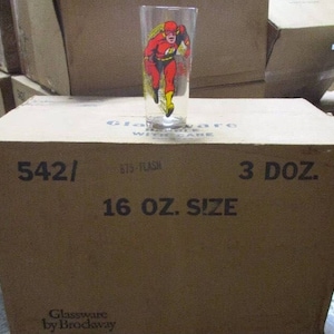 May include: A cardboard box with the text "542/ 875-FLASH ARE 16 OZ. SIZE 3 DOZ. Glassware by Brocksway" printed on it. The box contains a set of 3 dozen 16-ounce glass tumblers featuring a red and yellow illustration of The Flash.