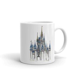 May include: White ceramic mug with a hand-drawn illustration of Cinderella's castle in a blue and gold color scheme.