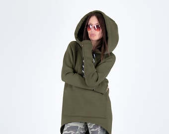 May include: A long-sleeved, olive green hoodie with a drawstring hood and a kangaroo pocket. The hoodie is asymmetrical, with a longer back hem. The model is wearing camouflage trousers.