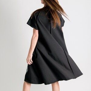 May include: A black short-sleeved dress with a loose fit and a flowing skirt. The dress is made of a soft, comfortable fabric.