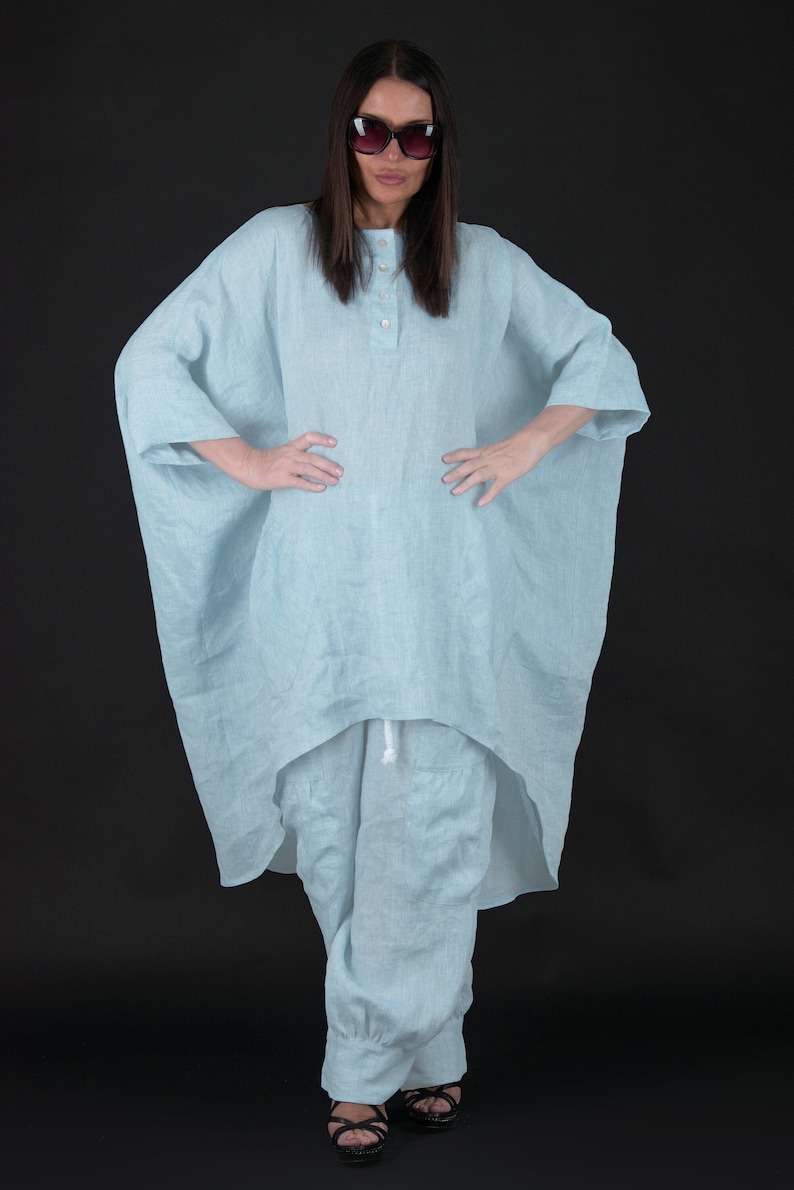 May include: A light blue linen tunic with a high-low hemline and a button-up front. The tunic is paired with matching light blue linen pants.