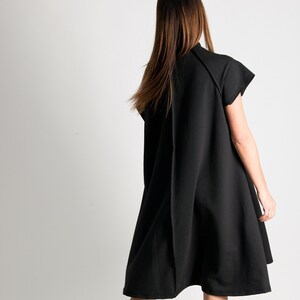 May include: A black sleeveless dress with a loose fit and a slightly flared hem.