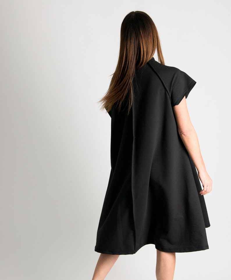 May include: A black sleeveless dress with a loose fit and a slightly flared hem.