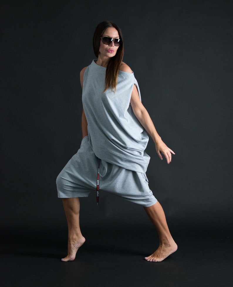 K&ouml;nnte beinhalten: Eine Frau tr&auml;gt ein locker sitzendes graues Outfit mit einer Kordeltaille und einem G&uuml;rtel, auf dem "LOVE LOVE LOVE" steht. Sie tr&auml;gt eine Sonnenbrille und hat ihr Haar offen.