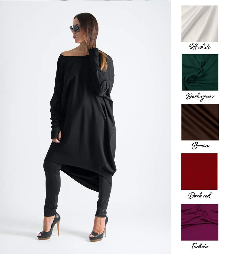 May include: A black long-sleeved tunic with a loose fit and a high, round neckline. The tunic is paired with black leggings and black high-heeled shoes.