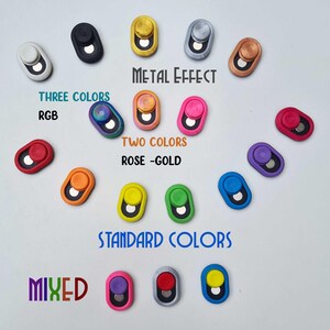 May include: A collection of oval buttons in a variety of colours, including metallic, two-tone, and standard shades. The image includes text that reads "Metal Effect", "Three Colors RGB", "Two Colors Rose - Gold", "Standard Colors", and "Mixed".