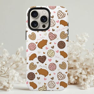 May include: White iPhone case with a repeating pattern of brown, pink, and tan pastries, hearts, and text. The case features images of conchas, orejas, and other Mexican sweet bread. The text reads "pan dulce" and "cafecito y chisme".