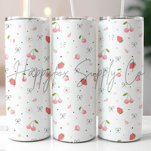 May include: Three white stainless steel tumblers with a pink and white cherry and strawberry pattern. The tumblers have black bows and dots.