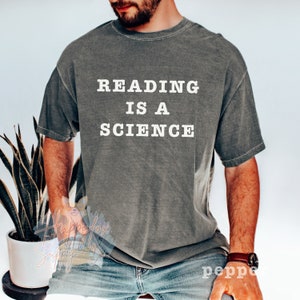 May include: A gray t-shirt with the text "READING IS A SCIENCE" printed in white.