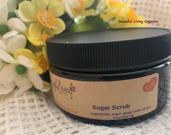 May include: A brown glass jar with a black lid containing a sugar scrub. The label is brown with white text that reads "Sugar Scrub" and "Ingredients: sugar, grape seed oil and Essential Oil". The label also has a small butterfly graphic and the word "Etsy" in a heart shape.