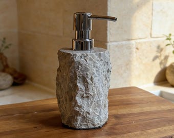 Dispensador de jabón artesanal de piedra natural. Elegante accesorio de baño con un diseño rústico único, ideal para la decoración de la cocina o el tocador.