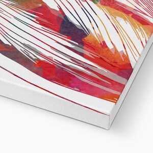 May include: A canvas print featuring an abstract watercolor design. The artwork showcases a vibrant mix of red, orange, and pink hues, with white linear brushstrokes. The canvas is stretched over a wooden frame, creating a modern art piece.