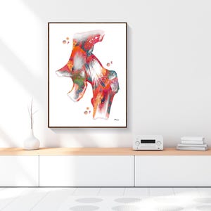 May include: A framed abstract watercolor print featuring a colorful anatomical illustration. The artwork showcases a vibrant mix of red, orange, and green hues, with white highlights. The print is displayed on a white wall above a wooden cabinet.