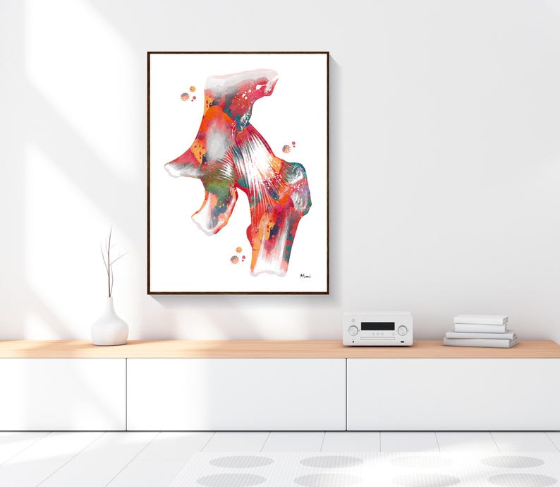 May include: A framed abstract watercolor print featuring a colorful anatomical illustration. The artwork showcases a vibrant mix of red, orange, and green hues, with white highlights. The print is displayed on a white wall above a wooden cabinet.