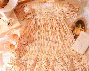 May include: A crocheted baby dress with a scalloped hem and matching bonnet. The dress is made in a delicate peach color and features a delicate floral pattern.