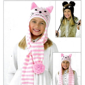 May include: Two children wearing pink and white striped knit hats and scarves with pom-poms. The hats have cat ears and faces. One child is wearing a brown and black bear hat with ears and pom-poms.