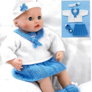 Puede incluir: Un conjunto de punto para muñeca en blanco y azul, con un jersey de marinero, falda, gorro y botines. El conjunto está diseñado para una muñeca de aproximadamente 46 cm de altura.