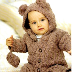 May include: A brown knitted baby bear costume with a hood and button closure. The costume has a fluffy texture and is perfect for a baby.
