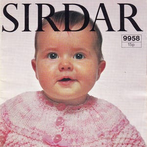 Puede incluir: Un bebé con una rebeca de punto rosa y blanco con tres botones rosas y una cinta decorativa. La imagen es de un patrón de tejido Sirdar vintage, con el nombre de la marca en la parte superior.