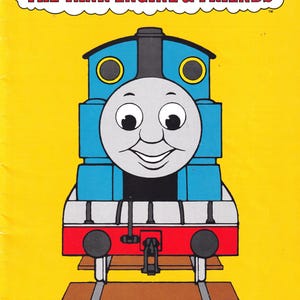 May include: A yellow book cover featuring Thomas the Tank Engine. The blue and red train is smiling, with the text "THOMAS THE TANK ENGINE & FRIENDS" above. The bottom reads "4 Knitting Patterns".