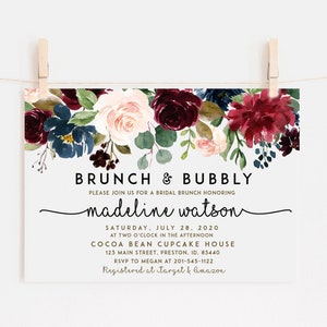 May include: A bridal shower invitation with a floral design in shades of burgundy, pink, and blue. The text reads "BRUNCH & BUBBLY" and "madeline watson". The invitation includes the date, time, location, and RSVP information.