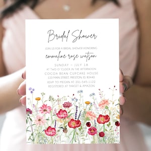 以下が含まれることがあります： 花柄のデザインが施されたブライダルシャワーの招待状。招待状は白地に黒文字で、上部に「Bridal Shower」と記載されています。下部のテキストには、「Join us for a bridal shower honoring Emmafine Rose Watson」とあり、日付、時間、場所、RSVP情報、レジストリ情報が記載されています。