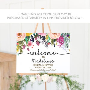 May include: A white welcome sign with a floral border and the text "welcome to Madeline's Bridal Shower August 16, 2024 34 days until she says "I do""