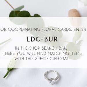 May include: White background with a silver ring, green leaves, and white flowers. Text reads: "FOR COORDINATING FLORAL CARDS, ENTER LDC-BUR IN THE SHOP SEARCH BAR. THERE YOU WILL FIND MATCHING ITEMS WITH THIS SPECIFIC FLORAL"