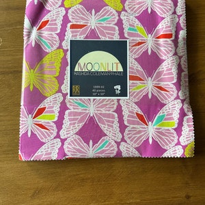 May include: A pack of 40 10-inch by 10-inch fabric squares featuring a pink background with a white butterfly pattern. The fabric squares are labeled "MOONLIT" by Rashida Coleman-Hale.
